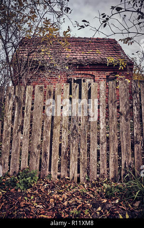 Alte holzzaun vor eine gespenstische, verlassenes Haus, Farbe Tonen angewendet. Stockfoto