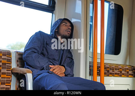 Ein schwarzer Mann schlafend auf eine U-Bahn Stockfoto