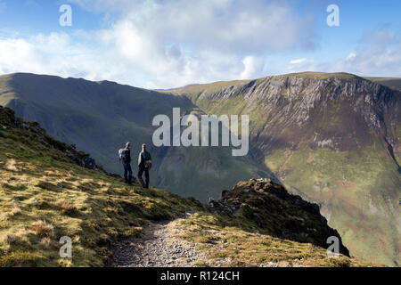 Zwei Wanderer erfreuen sich an der Aussicht von Aal Crag auf hohen Spy in Richtung Dale Head (links) und Hindscarth (rechts), Lake District, Cumbria, UK. Stockfoto