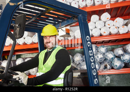 Lagerarbeiter als Gabelstapler Fahrer arbeitet auf dem Gabelstapler im Lager Stockfoto