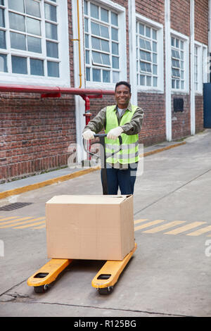 Afrikanische Logistik Mitarbeiter trägt ein Paket auf der Palette Lkw Stockfoto