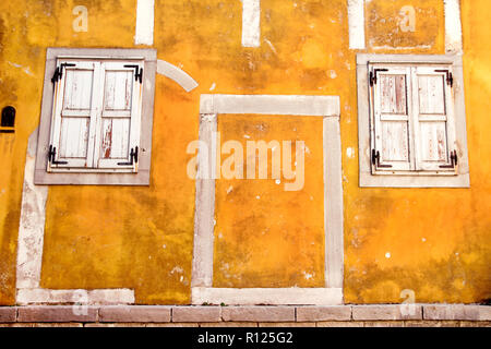 Alte gelbe Fassade/Classic vintage Holz Windows am gelben Gebäude aus Beton/der architektonischen Hintergrund, rustikalen Materialien und Textur, Nahaufnahme Stockfoto