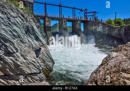 Chemal Dorf, Republik Altai, Russland - Juli 7, 2018: Alte Wasserkraftwerk in Tschemal River (altaigebirge). Blick auf die Brücke, Dam, Wasserfall Stockfoto