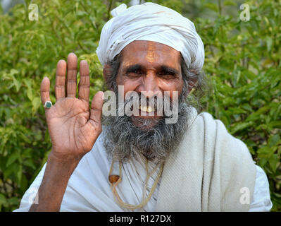 Alte Pilger mit einem weißen Turban hebt seine rechte Hand, um ein Segen zu geben. Stockfoto