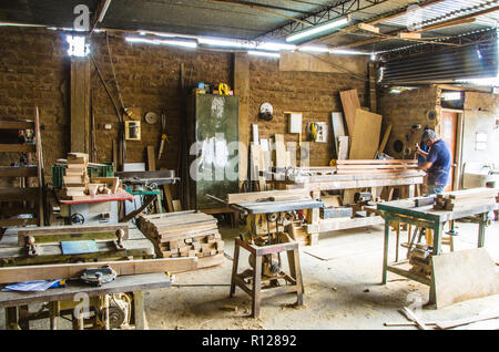 Mann tun Holzarbeiten in der Schreinerei. Schreinerei. Tischler arbeiten auf Holz Plank in der Werkstatt. Stockfoto