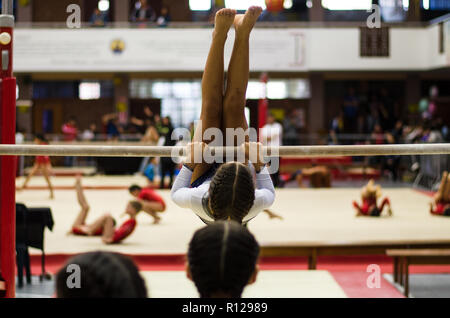Sportliche Mädchen gymnast Übungen an der Bar in der Meisterschaft Stockfoto