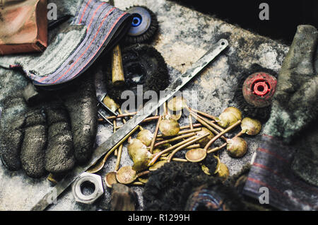 Blick von oben auf die verschiedenen Goldschmiede Werkzeuge auf den Schmuck am Arbeitsplatz. Desktop für Handwerk Schmuck machen mit professionellen Werkzeugen. Luftaufnahme von Werkzeugen über rustikal Hintergrund. Stockfoto