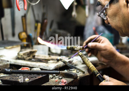 Master Juwelier Schweißen ein Ornament in einem Schmuck Werkstatt. Bild von Händen und Produkt. Stockfoto