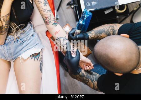 Tätowierer Zeichnung auf dem Arm des Kunden Stockfoto