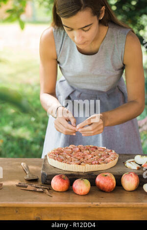 Frau bereitet Apple Pie auf Tisch Stockfoto