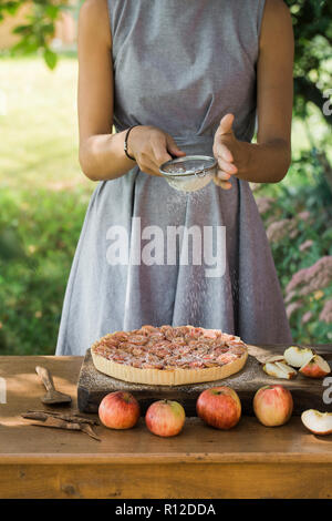 Frau bereitet Apple Pie auf Tisch Stockfoto