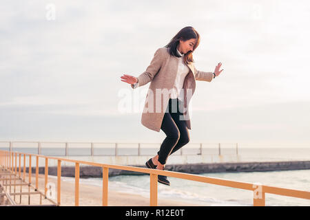 Frau springen Handlauf am Strand Stockfoto