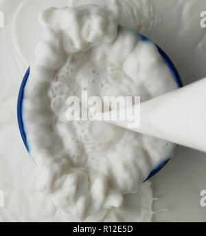 Milch in Schüssel geschüttet wurde Stockfoto