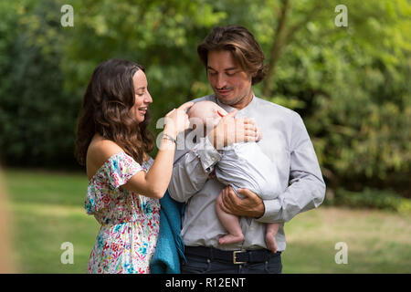 Der Mann und die Frau mit dem Baby im Garten Stockfoto