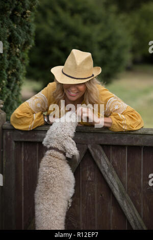 Frau spielen mit Hund im Garten Stockfoto