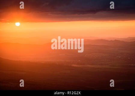 Sonnenuntergang in den Bergen - magische Licht auf der Oberseite des Vitosha Berges in Sofia, Bulgarien - die goldenen Sonnenstrahlen durch die dunklen Gewitterwolken Stockfoto