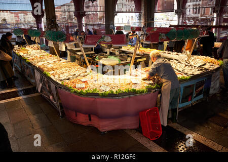 Venedig/Italien - 3. November 2018: Ein fischhändler legt seinem Stall in der Fischmarkt, oder Mercati di Rialto in Venedig, Italien. Stockfoto