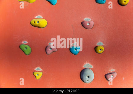 Klettern oder Bouldern Wand mit bunten Hand hält. Stockfoto