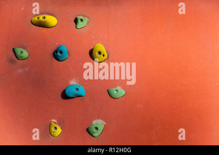 Klettern oder Bouldern Wand mit bunten Hand hält. Stockfoto