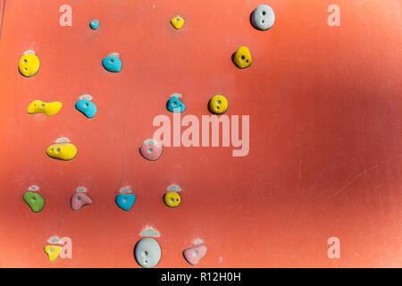 Klettern oder Bouldern Wand mit bunten Hand hält. Stockfoto
