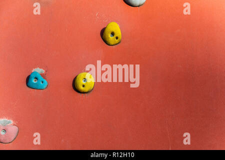 Klettern oder Bouldern Wand mit bunten Hand hält. Stockfoto