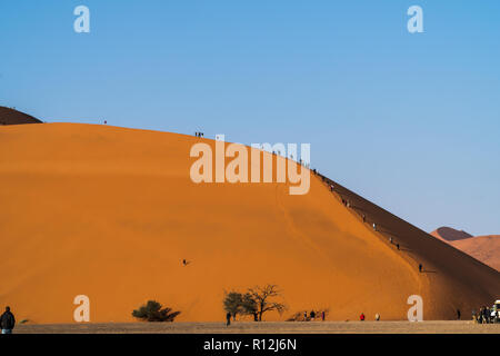 Touristen klettern auf Sanddünen, Sossusvlei, Namib-Wüste, Namib-Naukluft Park, Namibia Stockfoto