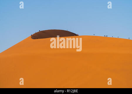 Touristen klettern auf Sanddünen, Sossusvlei, Namib-Wüste, Namib-Naukluft Park, Namibia Stockfoto