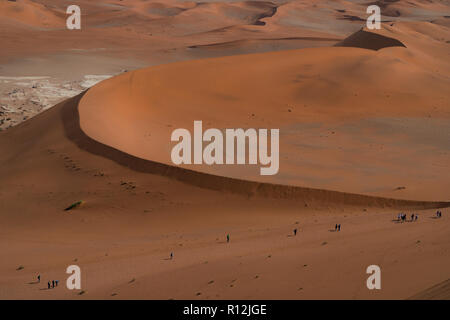 Touristen klettern auf Sanddünen, Sossusvlei, Namib-Wüste, Namib-Naukluft Park, Namibia Stockfoto