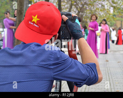 Professionelle vietnamesische Fotografin nimmt Portrait Fotos, die mit einer DSLR-Kamera Canon EOS 1DX in der Nähe von Hanoi die Bac Sohn Denkmal. Stockfoto