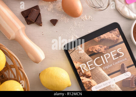 Tablet mit online Rezepte App und Gebäck Zutaten Hintergrund. Nutzung der digitalen Geräte zu kochen. Konzept der Rezepte in der digitalen Buch. Horizontale c Stockfoto