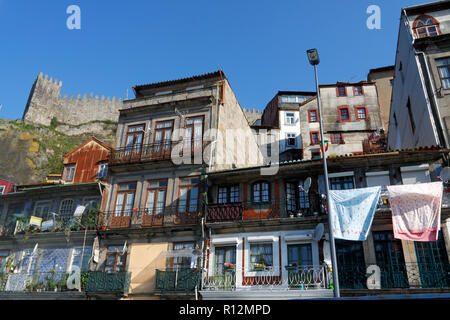 Typische Häuser von Porto zu sehen, im Hintergrund die alte Granit mittelalterlichen Stadtmauer mit Turm und Zinnen gegen den schönen blauen Himmel Stockfoto