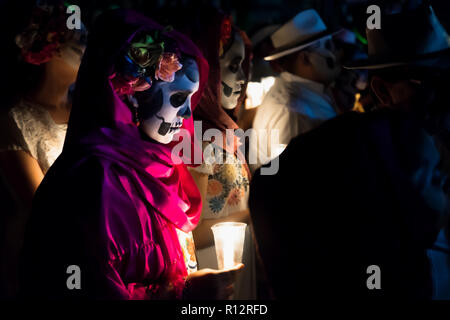 Merida, Cementerio General, Mexiko - 31. Oktober 2018: Nahaufnahme von Customed Frauen gekleidet wie Catrinas mit Totenkopf Make-up halten Kerzen in den Prozess Stockfoto