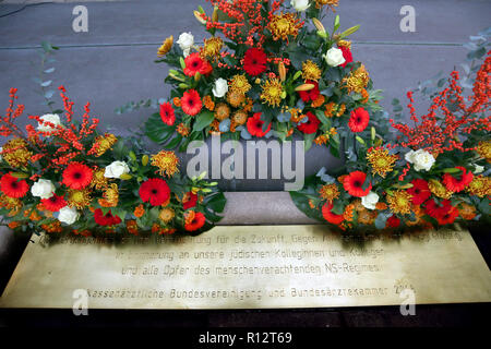 Berlin, Deutschland. 08 Nov, 2018. Blumen und eine Gedenktafel kann vor der Bundesverband der Gesetzlichen Krankenkassen Ärzte zu Beginn der Trauerfeier der Deutschen Ärzteschaft die Verfolgung der jüdischen Ärzte im Nationalsozialismus zu gedenken gesehen werden. Vor 80 Jahren, am 30. September 1938, jüdische Ärzte waren, denen die Lizenzen Medizin zu praktizieren. Quelle: Wolfgang Kumm/dpa/Alamy leben Nachrichten Stockfoto