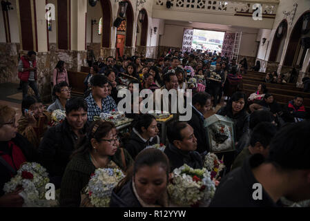 La Paz, Bolivien. 08 Nov, 2018. Personen menschlichen Schädeln geschmückt und in der Kirche der Friedhof von La Paz im Rahmen der beliebten Festival 'Las Natitas' durch einen Priester gesegnet werden warten. Bolivianer dekorieren menschlichen Schädeln auf dem Festival. Sie sind von guten Taten und Wunder vorgeworfen. Credit: Marcelo Perez del Carpio/dpa/Alamy leben Nachrichten Stockfoto