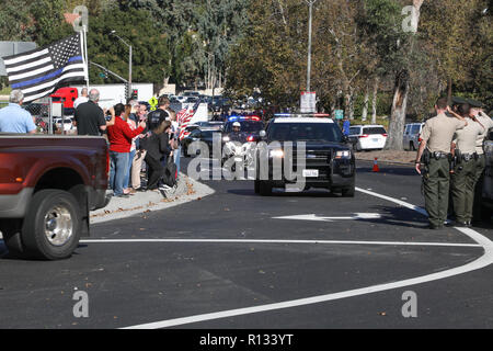 Thousand Oaks, Kalifornien, USA. 8. November 2018. Zuschauer schwenkten Fahnen und Offiziere grüßte die Prozession zu Ehren Sargeant Ron Helus, der erschossen wurde und während der Dreharbeiten an der Grenze Bar & Grill in Thousand Oaks, Kalifornien am Mittwoch abend getötet, wobei 13 Menschen tot. Sheri Determan/Alamy leben Nachrichten Stockfoto