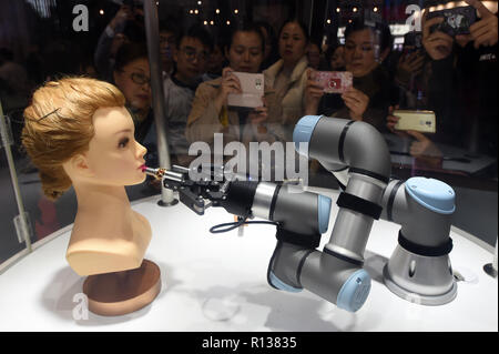 Shanghai, China. 9 Nov, 2018. Besucher sehen ein Roboterarm mit Make-up-Phobie bei der Bekleidung, Accessoires & Konsumgüter bereich der ersten China International Import Expo (CIIE) in Shanghai, China, November 9, 2018. Credit: Han Yuqing/Xinhua/Alamy leben Nachrichten Stockfoto
