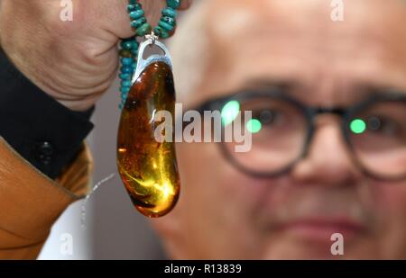 Shanghai, China. 9 Nov, 2018. Ein Aussteller aus Polen zeigt Bernsteinschmuck bei der Bekleidung, Accessoires & Konsumgüter bereich der ersten China International Import Expo (CIIE) in Shanghai, China, November 9, 2018. Credit: Sadat/Xinhua/Alamy leben Nachrichten Stockfoto