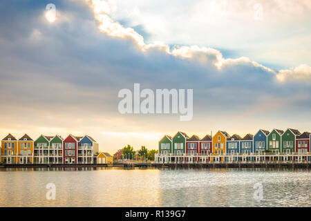 Niederländisch, modernen, farbenfrohen vinex Architektur Häuser am Wasser während der dramatischen und bewölkt, Sonnenuntergang. Houten, Utrecht. Stockfoto