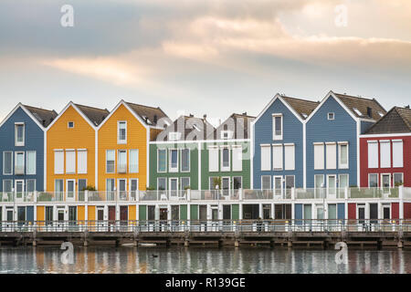 Niederländisch, modernen, farbenfrohen vinex Architektur Häuser am Wasser während der dramatischen und bewölkt, Sonnenuntergang. Houten, Utrecht. Stockfoto