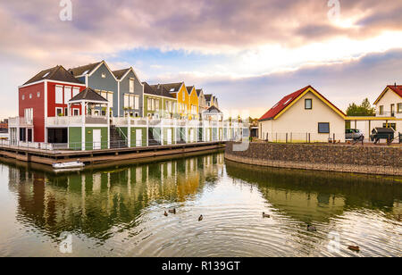 Niederländisch, modernen, farbenfrohen vinex Architektur Häuser am Wasser während der dramatischen und bewölkt, Sonnenuntergang. Houten, Utrecht. Stockfoto