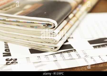 Stapel von frischen Morgen Zeitung am Tisch im Büro. Neueste Finanz- und Wirtschaftsnachrichten in der Tageszeitung. Seiten mit Informationen (Schlagzeilen, Artikel) Stockfoto