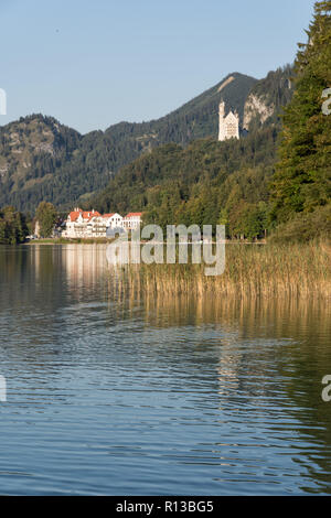 Alpsee, Füssen, mit Hohenschwangau, Neuschwanstein und Restaurant Alpenrose an einem warmen sonnigen Abend Ende September. Schwangau, Bayern Stockfoto