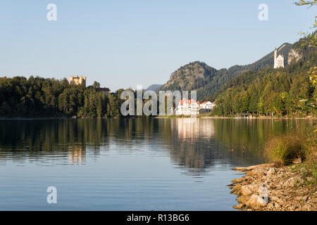 Alpsee mit Hohenschwangau, Neuschwanstein und Restaurant Alpenrose am See an einem sonnigen Abend Ende September.Schwangau, Füssen, Bayern Stockfoto