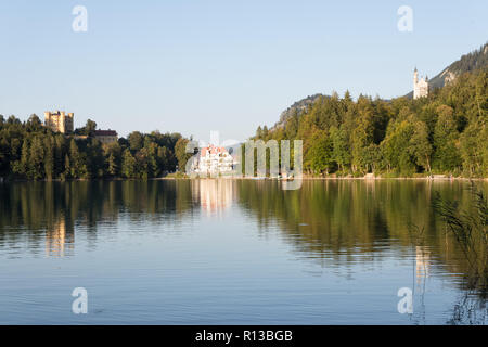 Alpsee, Füssen, mit Hohenschwangau, Neuschwanstein, Restaurant Alpenrose am See an einem warmen sonnigen Abend Ende September. Schwangau, Bayern Stockfoto