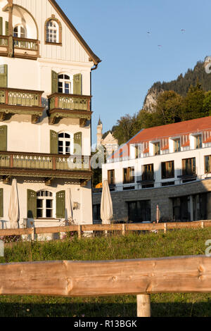 Schwangau, Bayern, Deutschland, 2018. Restaurant Alpenrose, das neu erbaute Hotel und das Schloss Neuschwanstein auf einem sonnigen Abend Ende September. Stockfoto