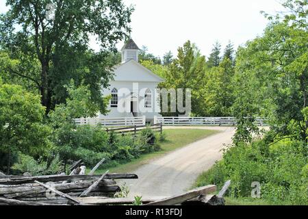 St Peter's Church Eagle, WI an einem Sommertag mit Schmutz der Straße und alten Holz Zaun vorne Stockfoto