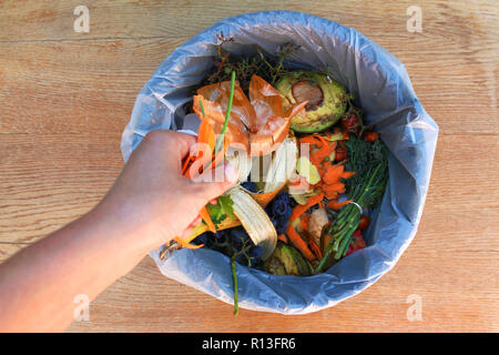 Hausmüll für Kompost von Obst und Gemüse. Frau wirft Müll. Stockfoto