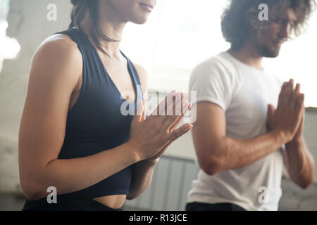 Junger Mann und Frau namaste Geste Yoga Lektion Stockfoto