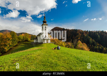 Mann mit Hund bewundern ländlichen Kapelle in Slowenien. Stockfoto