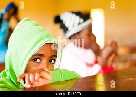 Bafoussam Kamerun - 06. August 2018: close up Portrait von jungen afrikanischen Schule Kind in Kamera mit Sorge und Hoffnung mit großen Augen suchen Stockfoto